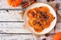 Pumpkin filled ravioli pasta above view on a rustic white wood background