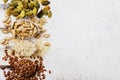 Pumpkin, flax, sesame and sunflower seeds in metal spoons on the left side of the table with copy space