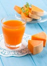 Pumpkin fresh juice in beautiful glasses and jug with pieces of ripe vegetable on white wooden background. Sweet orange juice. Hea Royalty Free Stock Photo