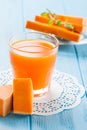 Pumpkin fresh juice in beautiful glasses and jug with pieces of ripe vegetable on white wooden background. Sweet orange juice. Hea Royalty Free Stock Photo