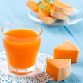 Pumpkin fresh juice in beautiful glasses and jug with pieces of ripe vegetable on white wooden background. Sweet orange juice. Hea Royalty Free Stock Photo