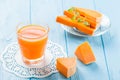 Pumpkin fresh juice in beautiful glasses and jug with pieces of ripe vegetable on white wooden background. Sweet orange juice. Hea Royalty Free Stock Photo