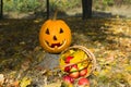 Pumpkin - head and basket with apples on background of yellow leaves