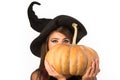 Pumpkin head jack lantern. Trick or treat. Woman posing with Pumpkin. Beautiful young surprised woman in witches hat and Royalty Free Stock Photo