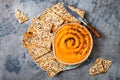 Pumpkin hummus seasoned with olive oil and black sesame seeds with whole grain crackers. Healthy vegetarian appetizer or snack. Royalty Free Stock Photo