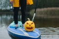 Pumpkin on inflatable Board with paddle, sup surfing in autumn