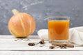 Pumpkin juice in glass on a wooden table. Spices cinnamon sticks and star anise. Royalty Free Stock Photo