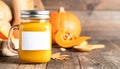 Pumpkin Juice in a Mason Jar with Blank Label Surrounded by Pumpkins on Rustic Wood Table Royalty Free Stock Photo