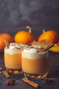 Pumpkin latte drink. Autumn coffee with spicy pumpkin flavor and cream on a dark background. Seasonal Fall Drinks for Halloween