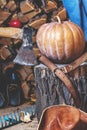 Pumpkin lies on tree stump on background of chopped firewood Royalty Free Stock Photo