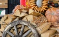 A pumpkin, an old wooden wheel, and a pile of wood. Rural-style decorations