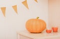 pumpkin and orange flags bunting. glowing candles with pumpkin fragrance. home decor for halloween celebration. autumn