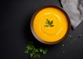 Pumpkin orange puree soup in a bowl on a dark background, minimalistic photo. Autumn dish of seasonal vegetables