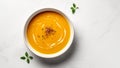 Pumpkin orange puree soup in a bowl on a white background, minimalistic photo. Autumn dish of seasonal vegetables