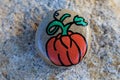 Pumpkin painted on a small rock