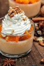 Pumpkin parfait with whipped cream, nuts in glass. Delicious breakfast or snack