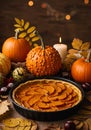Pumpkin pie set on a table adorned with autumn decorations Royalty Free Stock Photo