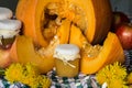 Pumpkin puree or jam on a background of cut pumpkin. Autumn still life. Royalty Free Stock Photo