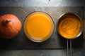 Pumpkin puree in a saucepan, pumpkin soup and pumpkin on a gray stone