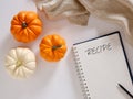 Pumpkin recipes concept. White and orange colored pumpkins with a notebook with the word recipe Royalty Free Stock Photo