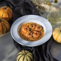 pumpkin risotto with grilled shrimp on a white plate Royalty Free Stock Photo