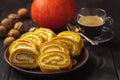 Pumpkin roll cake with cream filling., on dark wooden background. Royalty Free Stock Photo