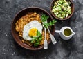 Pumpkin rostis with fried egg and avocado salsa on dark background, top view. Delicious breakfast, snack Royalty Free Stock Photo