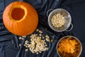 Pumpkin seed harvesting, seeds in a colander and pumpkin guts in a bowl