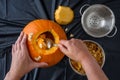 Pumpkin seed harvesting, womanÃ¢â¬â¢s hand scooping seeds out of fresh pumpkin with a spoon