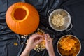 Pumpkin seed harvesting, womanÃ¢â¬â¢s hands sorting seeds and pumpkin guts