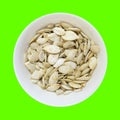 Pumpkin seeds bowl isolated on green Royalty Free Stock Photo