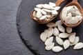 Pumpkin seeds and a wooden spoon on a dark table. Black slateboard with wooden bowl. Copy space Royalty Free Stock Photo