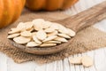 Pumpkin seeds in a wooden spoon on old wooden table.