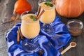 Pumpkin smoothie with cinnamon and granola on the old wooden background. Royalty Free Stock Photo