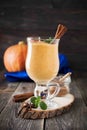 Pumpkin smoothie with cinnamon and granola on the old wooden background. Royalty Free Stock Photo