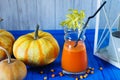 Pumpkin smoothie with pumpkins on a blue wooden background, deto