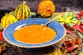 Pumpkin soup in a blue ceramic plate and a spoon Vintage tinted Royalty Free Stock Photo