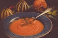 Pumpkin soup in a blue ceramic plate and a spoon Vintage tinted Royalty Free Stock Photo