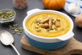 Pumpkin soup in a bowl,with fresh pumpkin seeds. Autumn foods. Healthy, vegetarian food, dark background