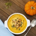 Pumpkin soup in a bowl,with fresh pumpkin seeds. Autumn foods. Healthy, vegetarian food, wooden background. Square image Royalty Free Stock Photo