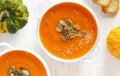 Pumpkin soup bowl with seeds on white wooden background. Top view. Royalty Free Stock Photo