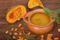 Pumpkin soup in clay pot with fresh pumpkins Royalty Free Stock Photo