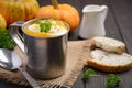 Pumpkin soup with cream and parsley in a mug on wooden background. Royalty Free Stock Photo