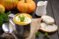 Pumpkin soup with cream and parsley in a mug on wooden background Royalty Free Stock Photo