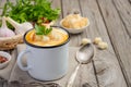 Pumpkin soup with cream and parsley in a mug on wooden background Royalty Free Stock Photo