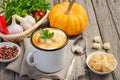 Pumpkin soup with cream and parsley in a mug on wooden background Royalty Free Stock Photo