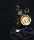 Pumpkin soup with cream, seeds and spices in rustic metal bowl over black background. Top view. Royalty Free Stock Photo