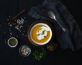 Pumpkin soup with cream, seeds and spices in rustic metal bowl over black background. Top view. Royalty Free Stock Photo