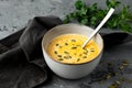 Pumpkin soup in deep bowl with seeds and spoon served with napkin and fresh green Royalty Free Stock Photo