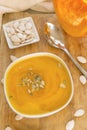 Pumpkin soup in a plate, pumpkin seeds, spoon, a piece of fresh Royalty Free Stock Photo